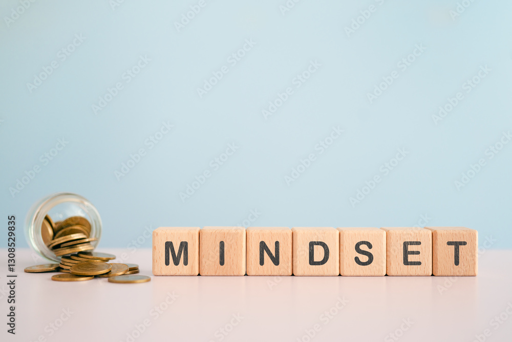 For business mindset concept, MINDSET text on wooden cube blocks with blurred coins in jar including copy space